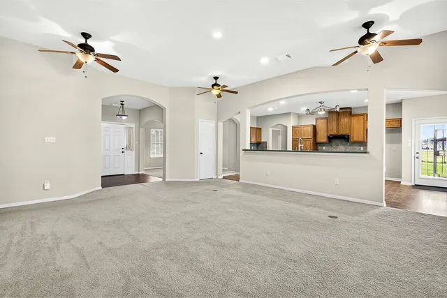 an empty room with fan and windows