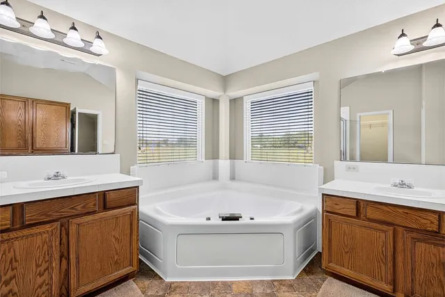 a bathroom with a tub sink and mirror