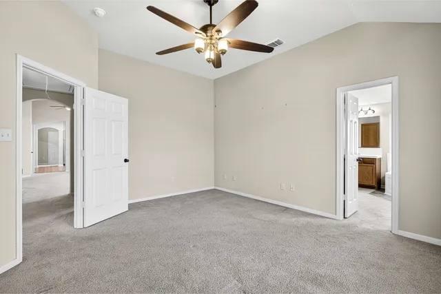 an empty room with a ceiling fan and a window