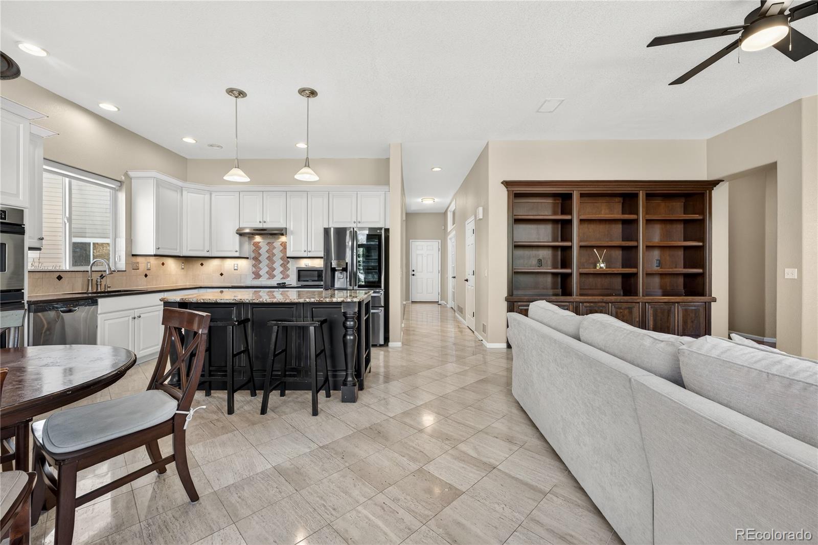 10155 Joseph Drive Highlands Ranch, CO 80124 - Photo 14 of 50 a kitchen with a dining table chairs refrigerator and cabinets