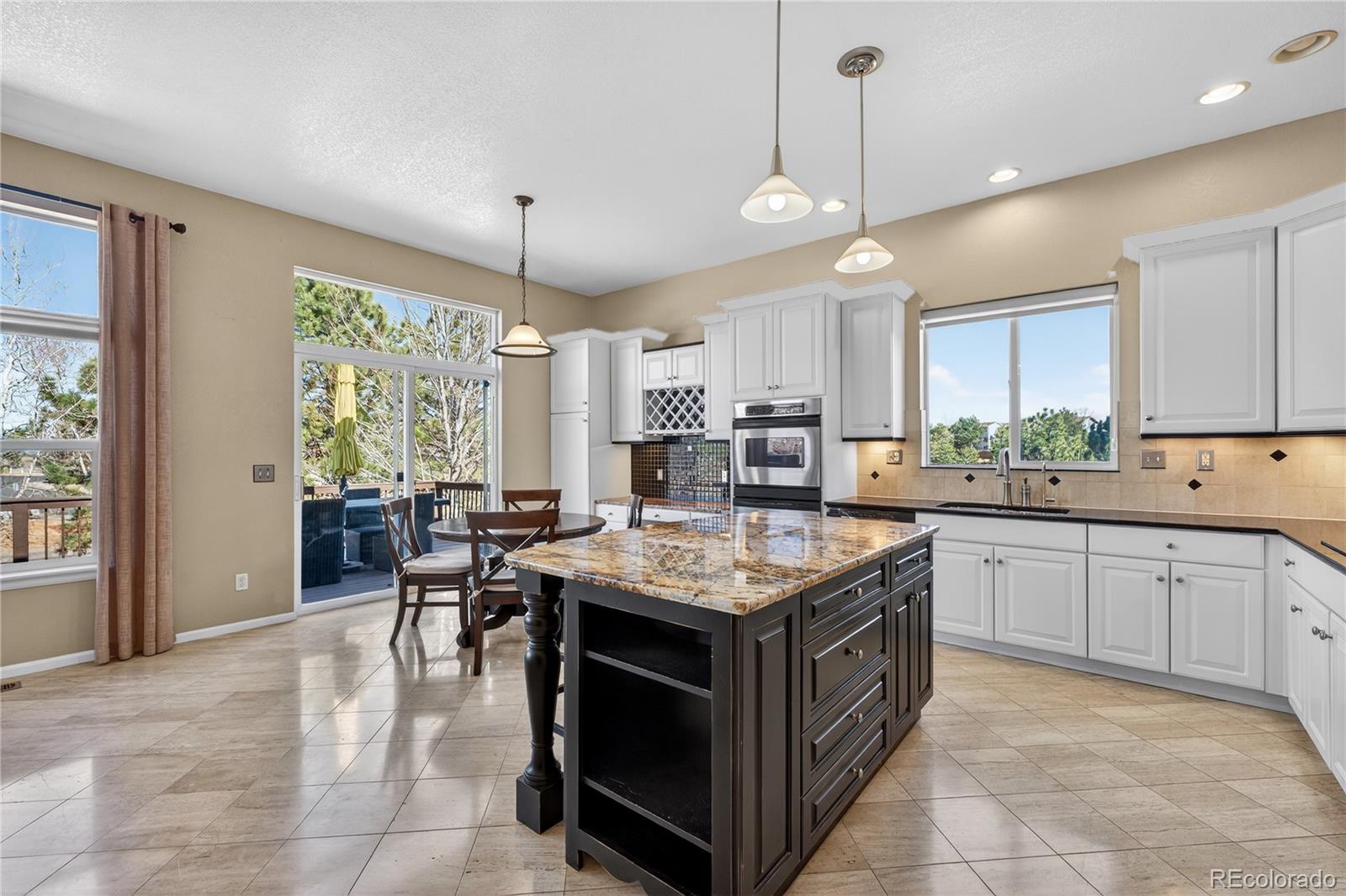 10155 Joseph Drive Highlands Ranch, CO 80124 - Photo 19 of 50 a kitchen with a stove a window and chairs