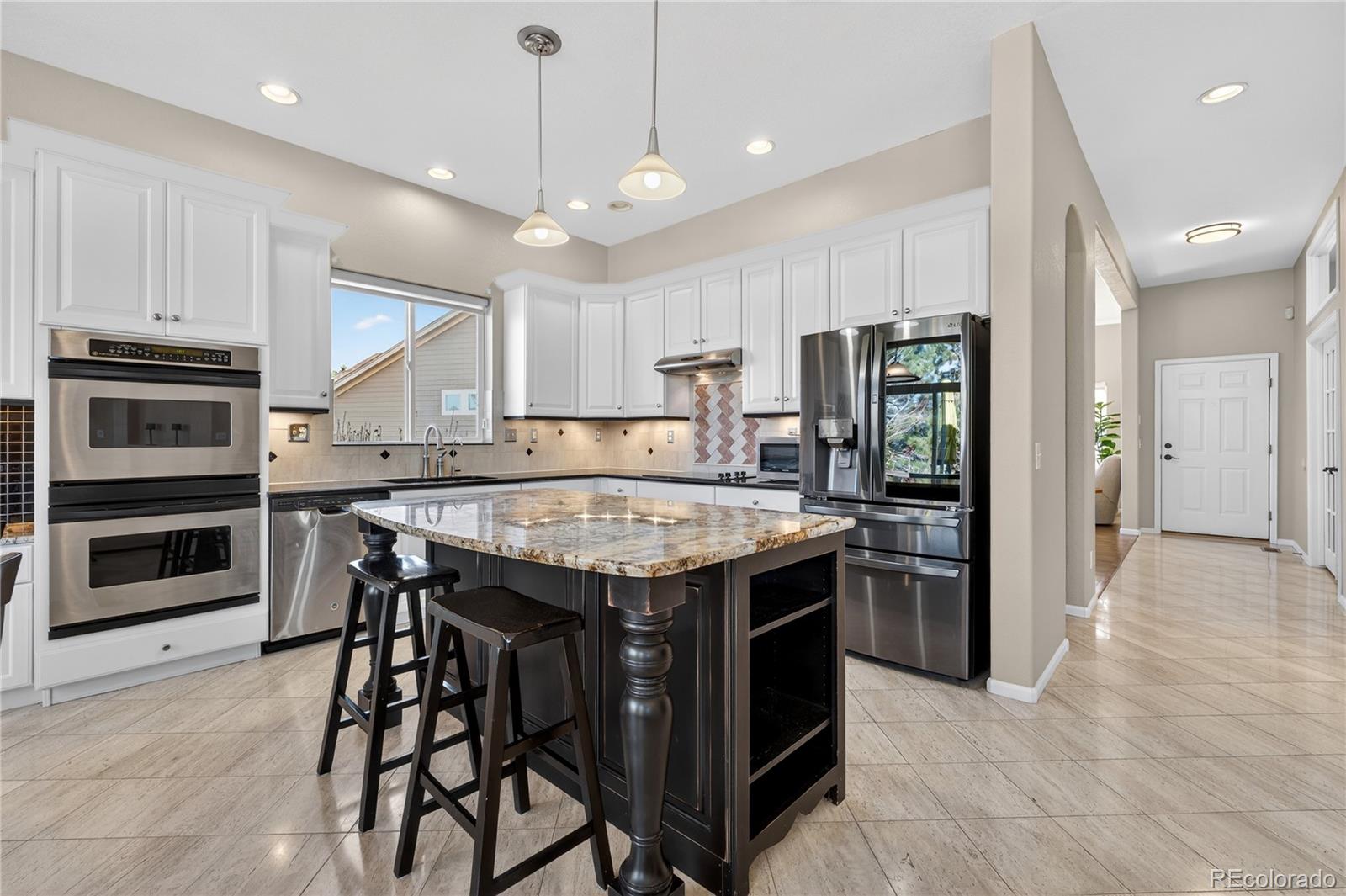 10155 Joseph Drive Highlands Ranch, CO 80124 - Photo 20 of 50 a kitchen with a stove a refrigerator and a microwave