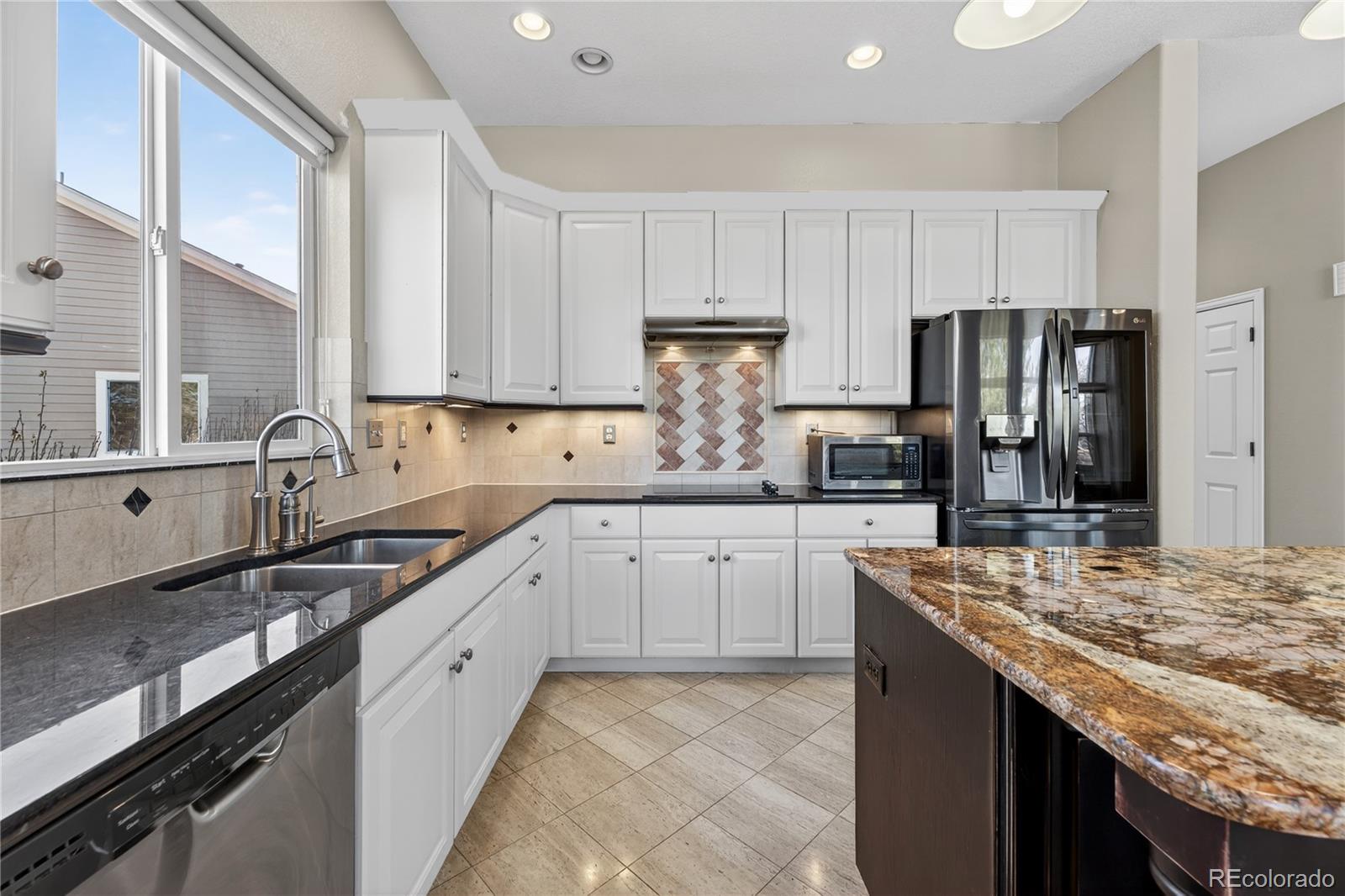 10155 Joseph Drive Highlands Ranch, CO 80124 - Photo 22 of 50 a kitchen with granite countertop stainless steel appliances and white cabinets