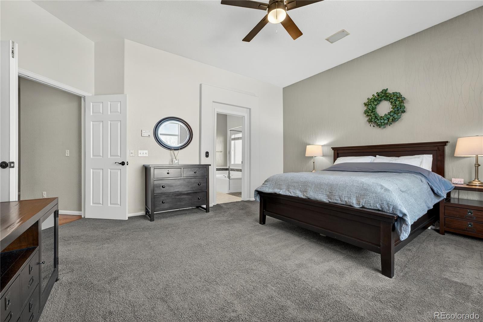 10155 Joseph Drive Highlands Ranch, CO 80124 - Photo 31 of 50 a spacious bedroom with a bed and a chandelier