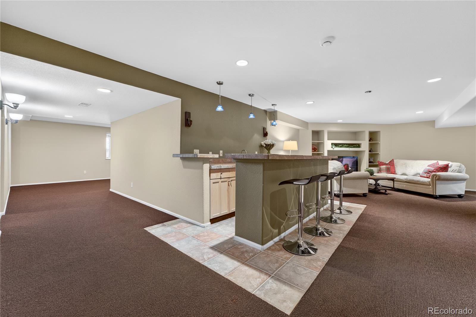 10155 Joseph Drive Highlands Ranch, CO 80124 - Photo 41 of 50 a living room with furniture a kitchen view and a fireplace