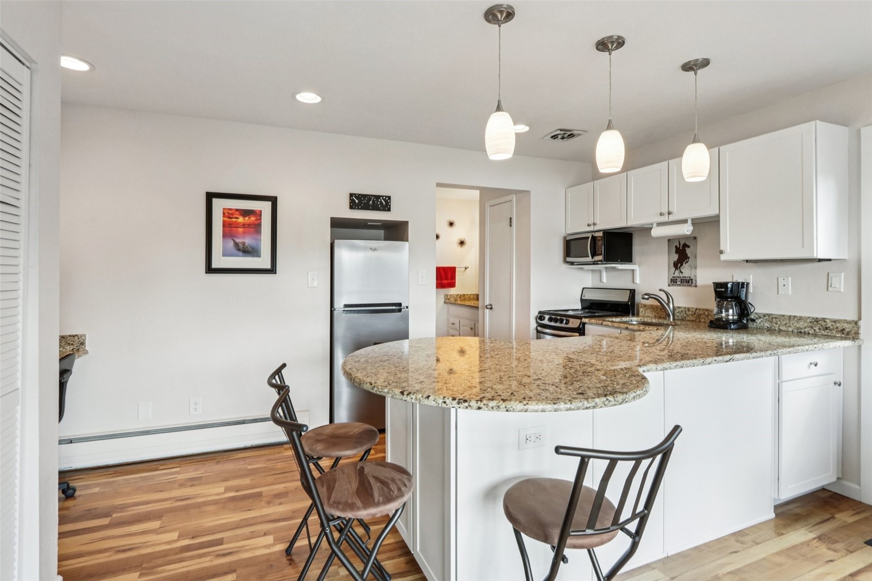 144 Gold Run Circle, Unit 17 Dillon, CO 80435 - Photo 5 of 38 a kitchen with stainless steel appliances granite countertop a stove a sink a microwave a refrigerator with white cabinets and wooden floor