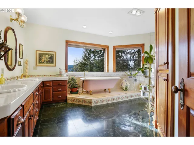 a bathroom with a tub sink and mirror