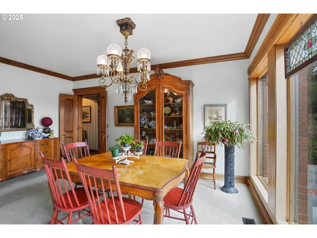 a dining room with wooden floor a chandelier a wooden table and chairs