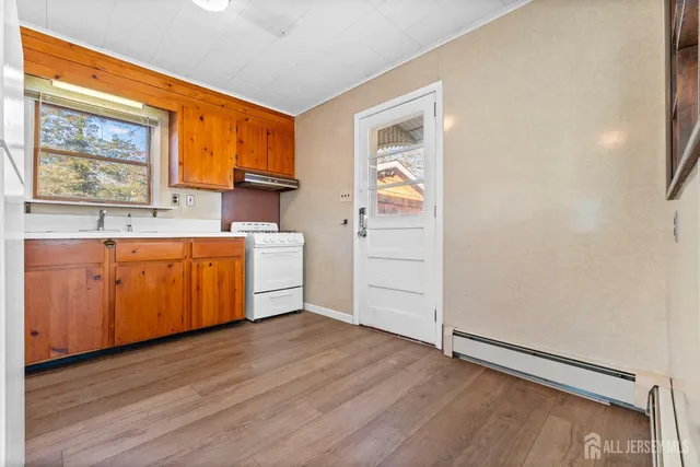 a view of a kitchen with a sink dishwasher and wooden floor