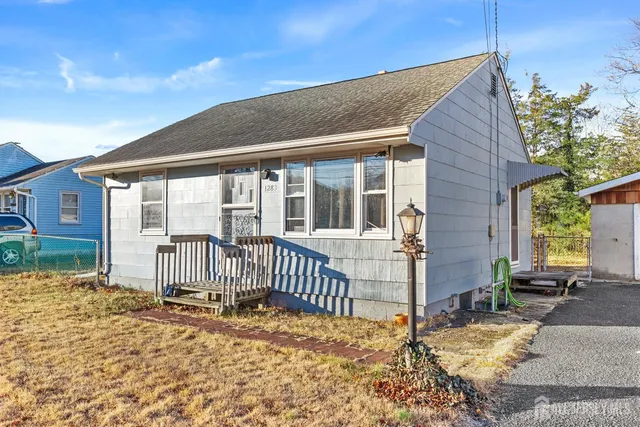 a view of a house with a floor to ceiling window and wooden fence