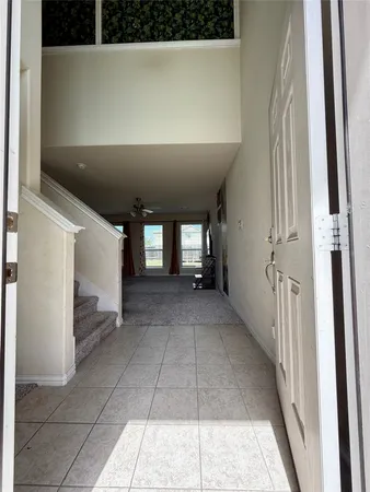 a view of an empty room with a chandelier fan