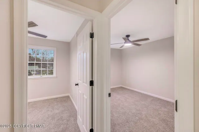 an empty room with chandelier fan