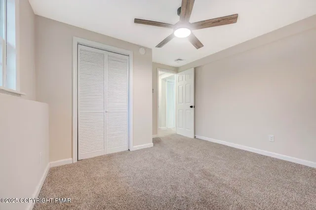 a view of backyard of house with wooden deck and seating space