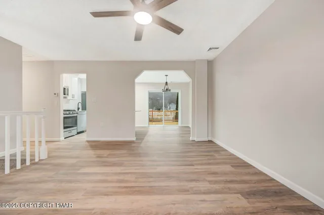 a kitchen with stainless steel appliances a sink a stove a refrigerator cabinets and wooden floor