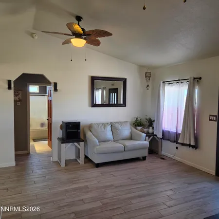 a living room with stainless steel appliances furniture and a flat screen tv
