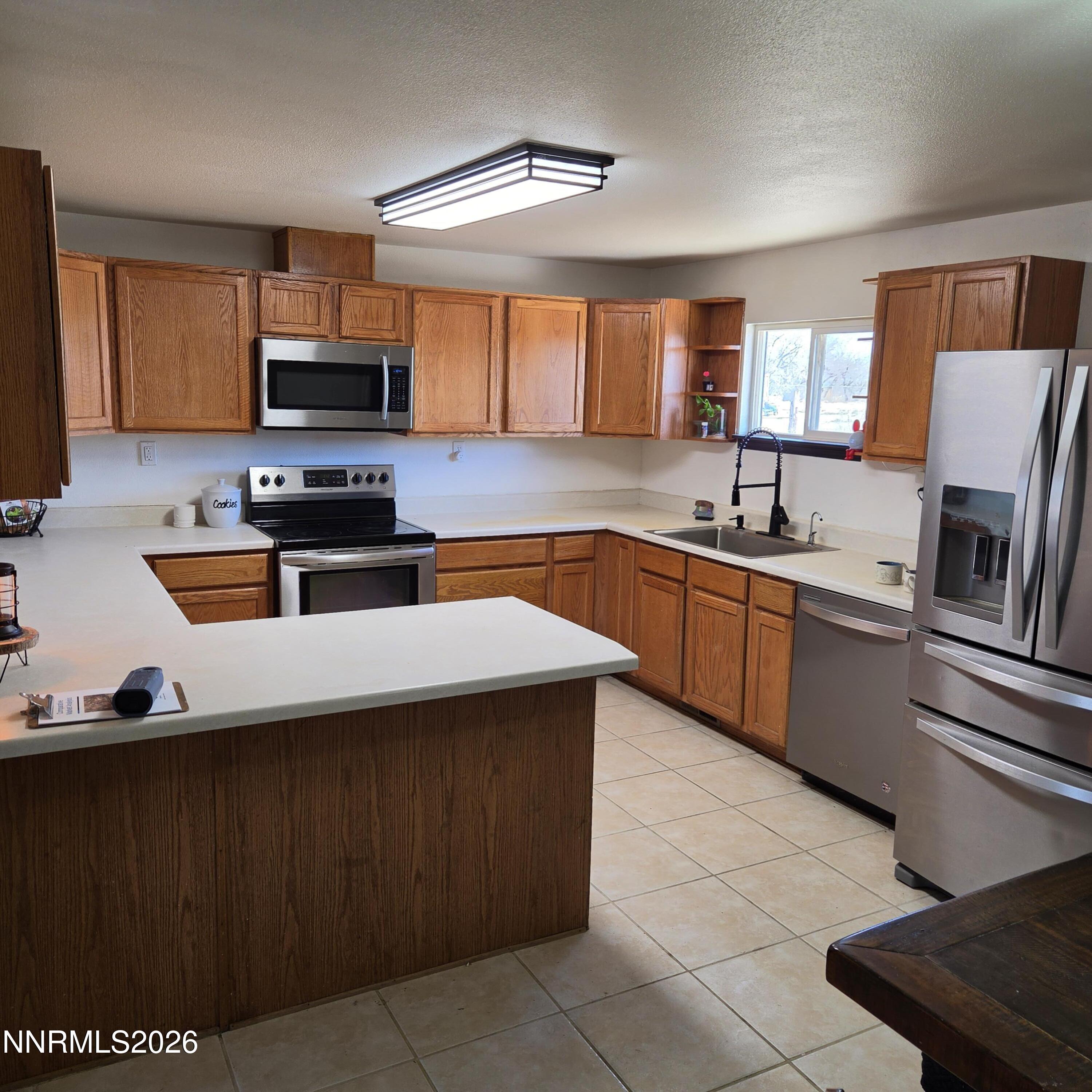 1080 Tarzyn Road Fallon, NV 89406 - Photo 22 of 41 a kitchen with stainless steel appliances a sink a stove a microwave a sink a refrigerator and cabinets