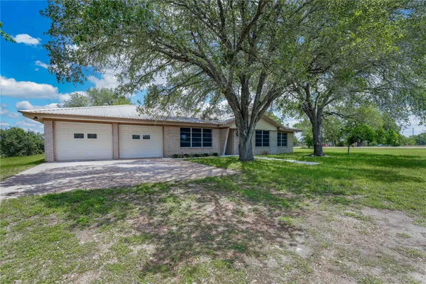a view of a house with yard and tree s