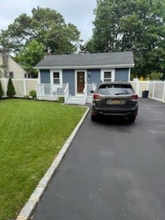 a car parked in front of a house and a yard