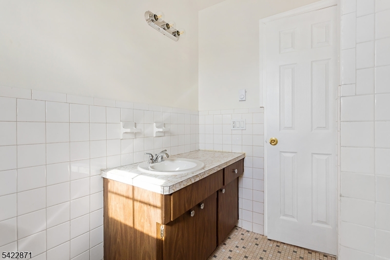 145 Arnot Street, Unit 4B Lodi, NJ 07644 - Photo 16 of 21 a bathroom with a sink vanity and a mirror