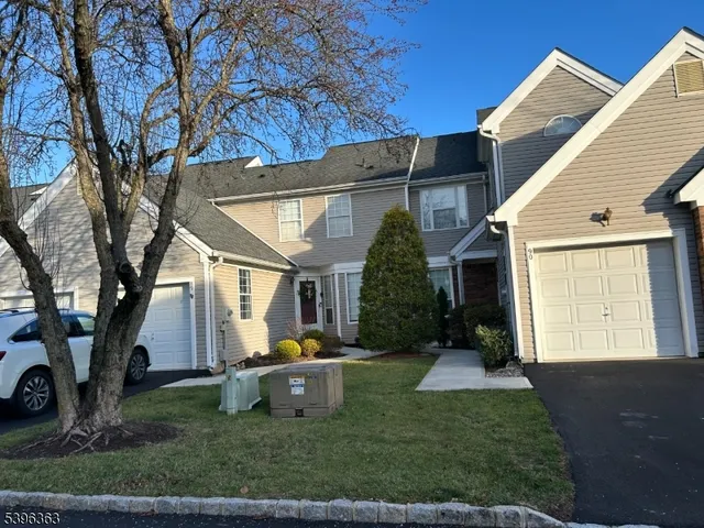 a view of a house with backyard and a tree