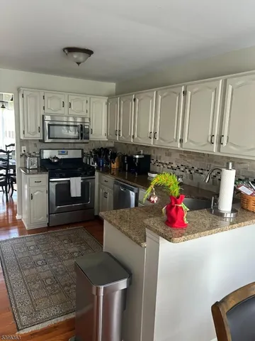 a kitchen with stainless steel appliances granite countertop a stove sink and cabinets