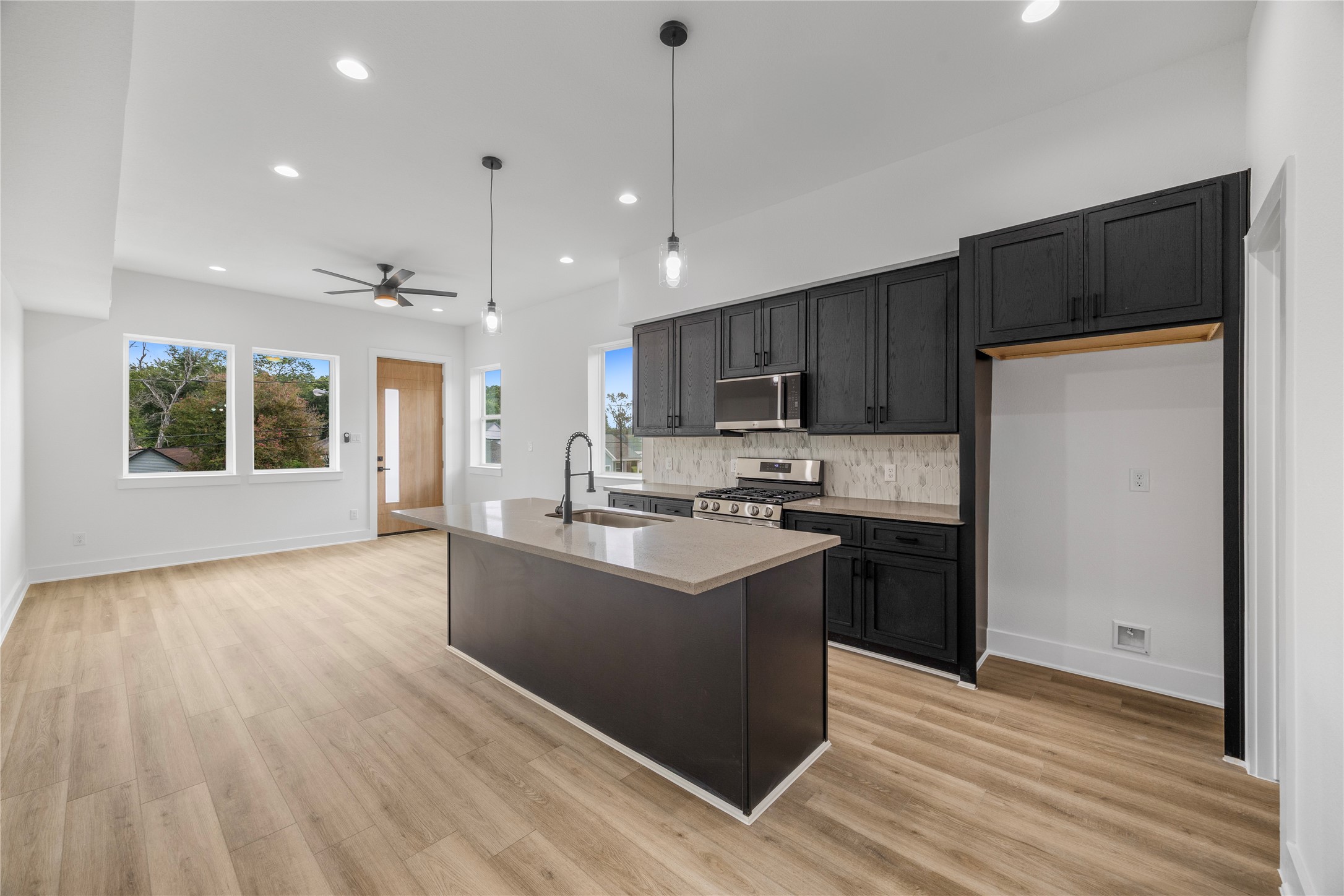 7901 Cora Street, Unit B Houston, TX 77088 - Photo 3 of 21 a kitchen with stainless steel appliances granite countertop a refrigerator a stove top oven a sink dishwasher and a refrigerator with wooden floor