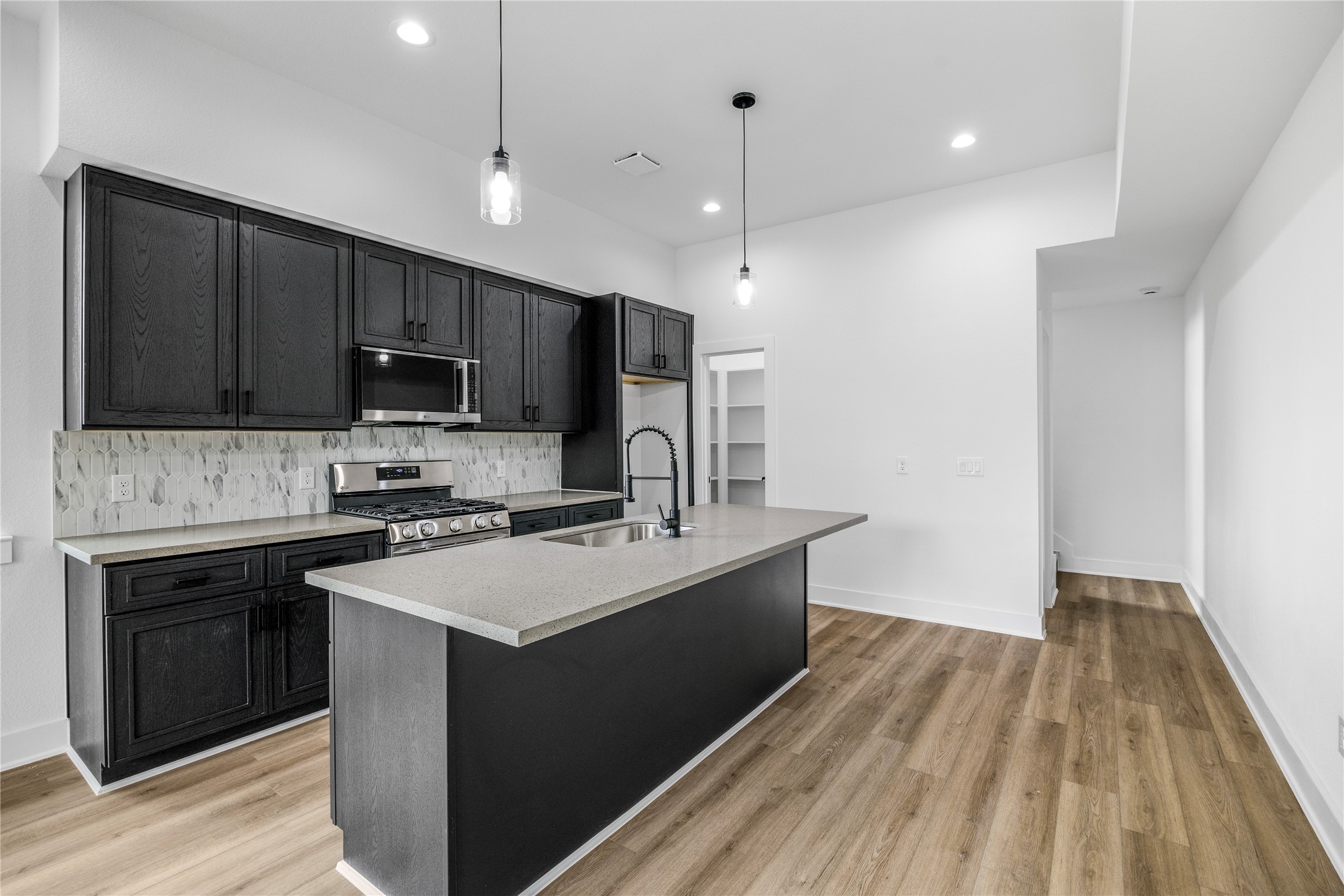 7901 Cora Street, Unit B Houston, TX 77088 - Photo 5 of 21 a kitchen with kitchen island a sink stainless steel appliances and cabinets