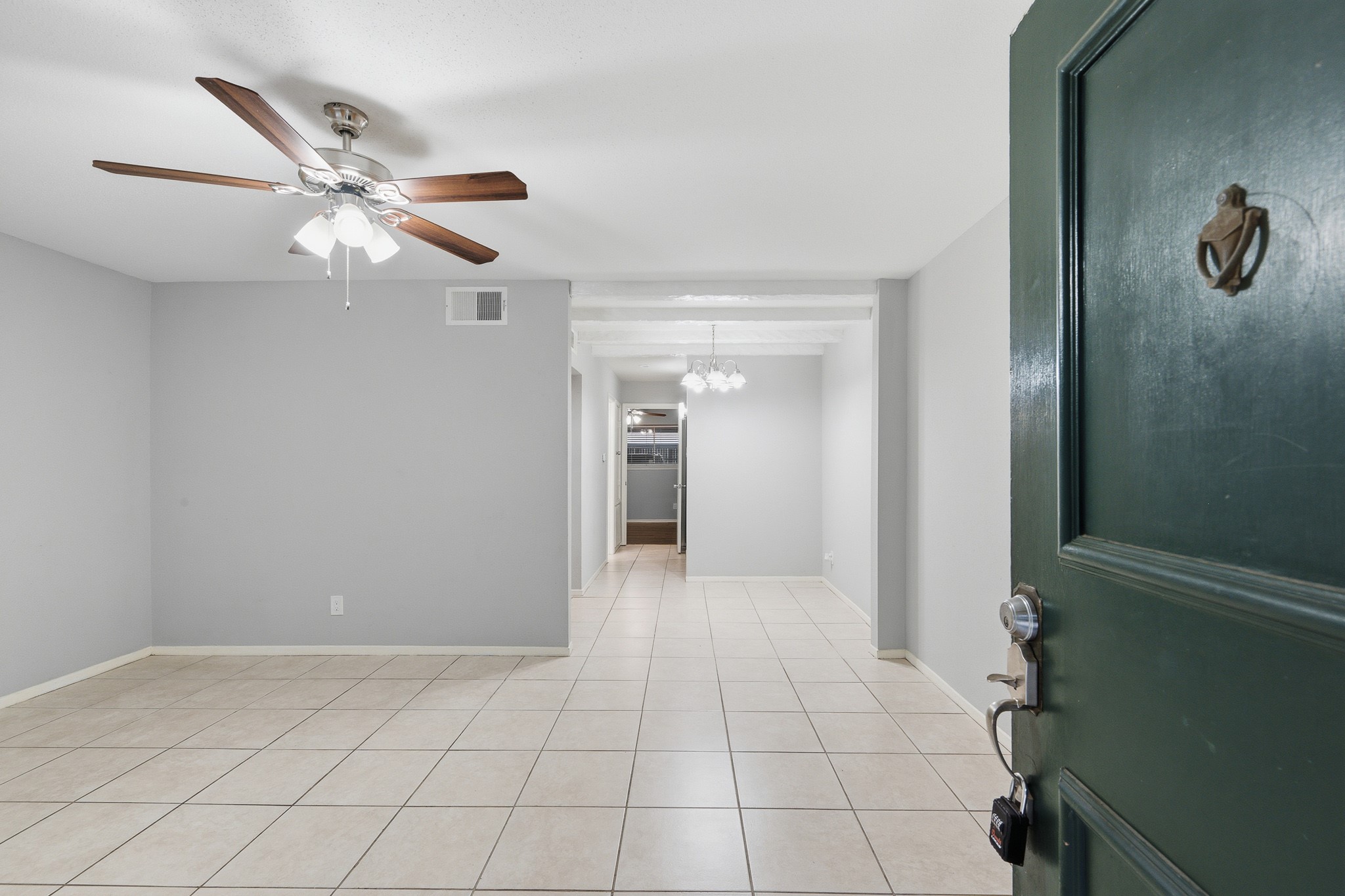 11550 Chimney Rock Road, Unit 133 Houston, TX 77035 - Photo 4 of 40 Spacious living area with neutral tile flooring, modern ceiling fan, and ample natural light.