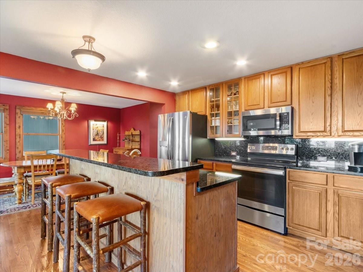 121 Ivy Ridge Road Burnsville, NC 28714 - Photo 12 of 48 a kitchen with stainless steel appliances granite countertop a stove top oven a sink and cabinets