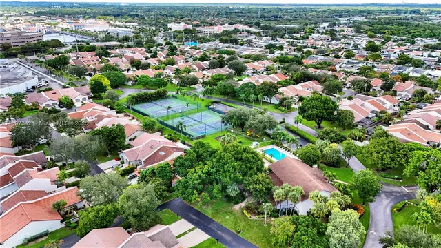 an aerial view of residential houses with outdoor space and trees all around