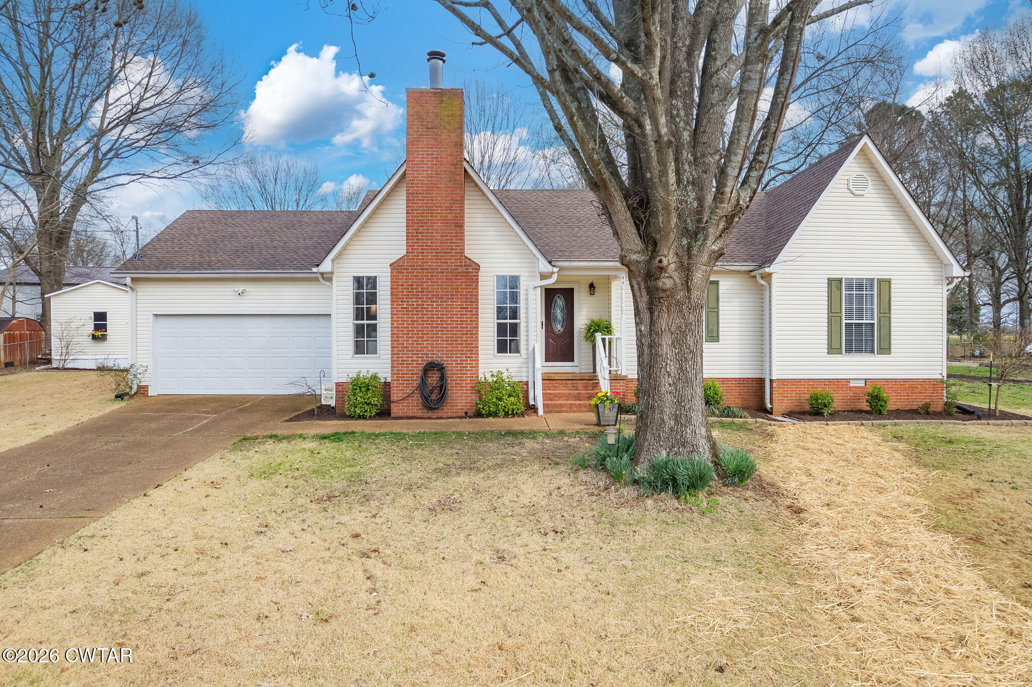 a view of a house with backyard and trees