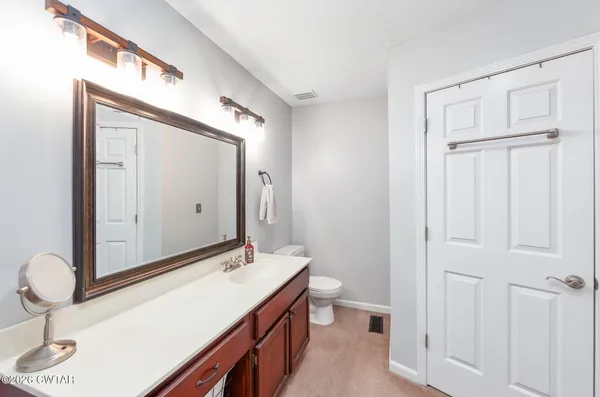 a bathroom with a sink a toilet and a mirror