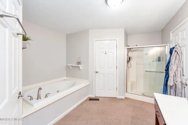 a bathroom with a tub a sink and a shower