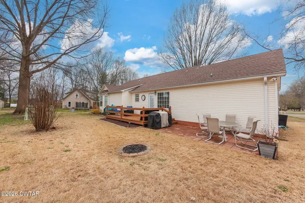 a view of a backyard with table and chairs and a barbeque