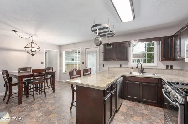 a kitchen with stainless steel appliances granite countertop a sink a stove and a refrigerator