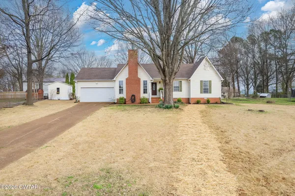 a front view of a house with a yard and trees