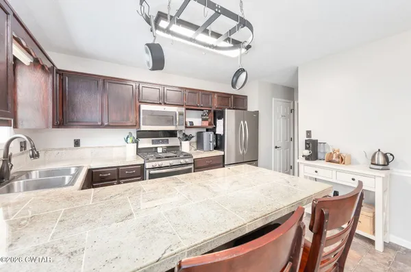 a kitchen with stainless steel appliances kitchen island granite countertop a sink and cabinets