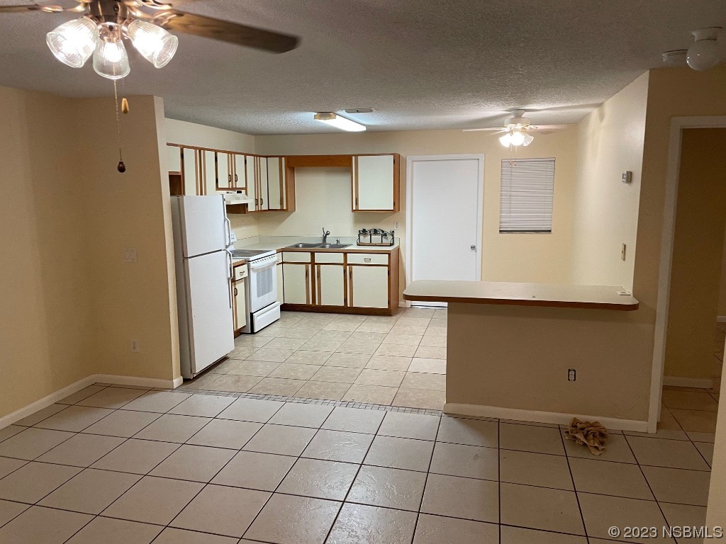 2352 Fern Palm Drive Edgewater, FL 32141 - Photo 4 of 12 a kitchen with stainless steel appliances a refrigerator and a stove top oven