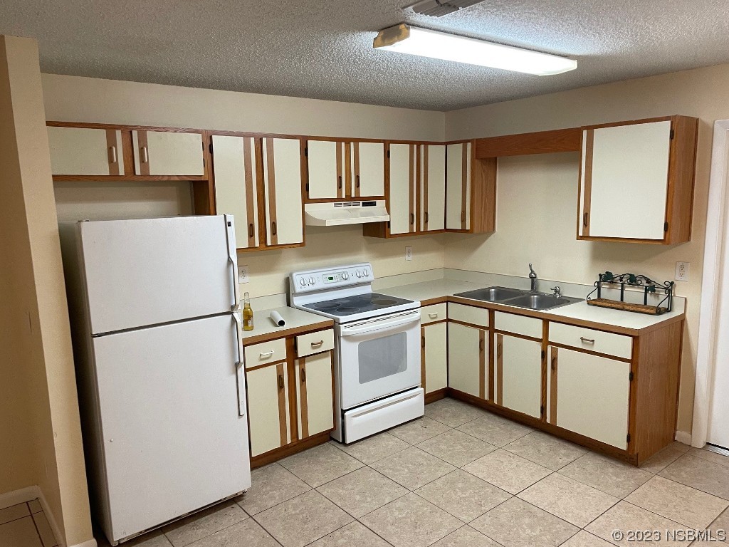 2352 Fern Palm Drive Edgewater, FL 32141 - Photo 5 of 12 a kitchen with white cabinets and white appliances