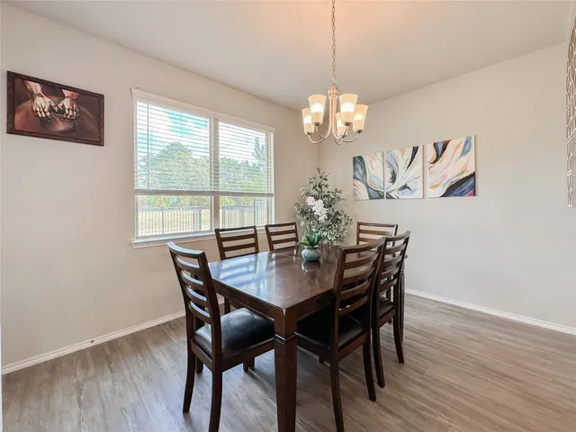 a view of a dining room with furniture a chandelier and wooden floor