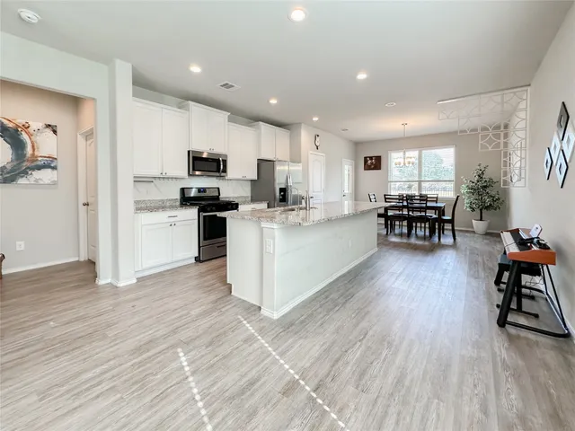 a view of a livingroom with dining room and wooden floor