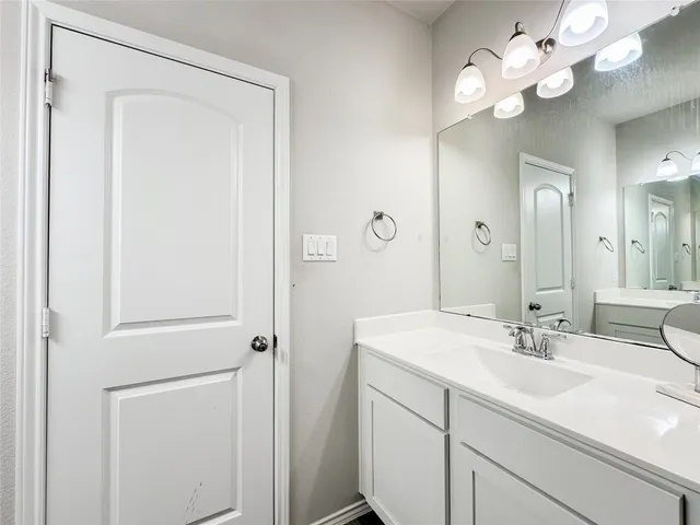 a bathroom with a sink a light fixture and a mirror