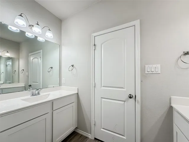 a bathroom with a sink a mirror and vanity
