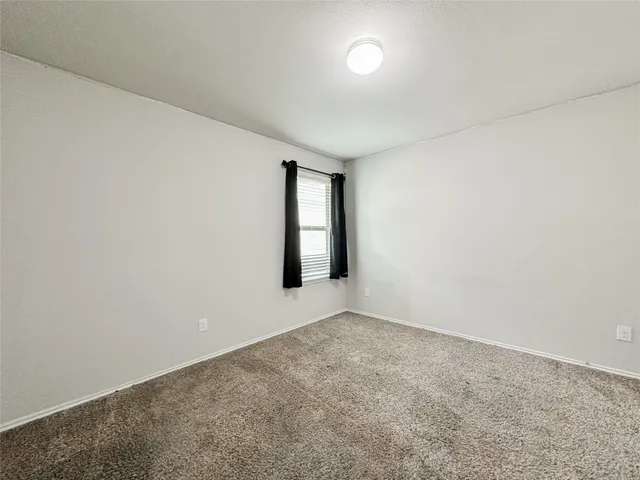 a view of an empty room with wooden floor and closet