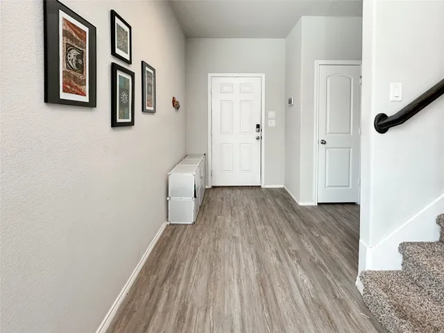 a view of a hallway with wooden floor and staircase
