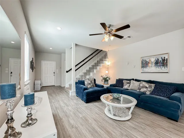 a living room with furniture and a wooden floor