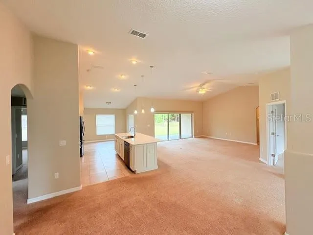 a view of a big room with windows and chandelier