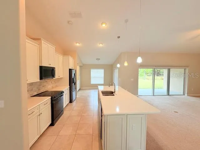 a large kitchen with kitchen island a sink a counter top space and stainless steel appliances