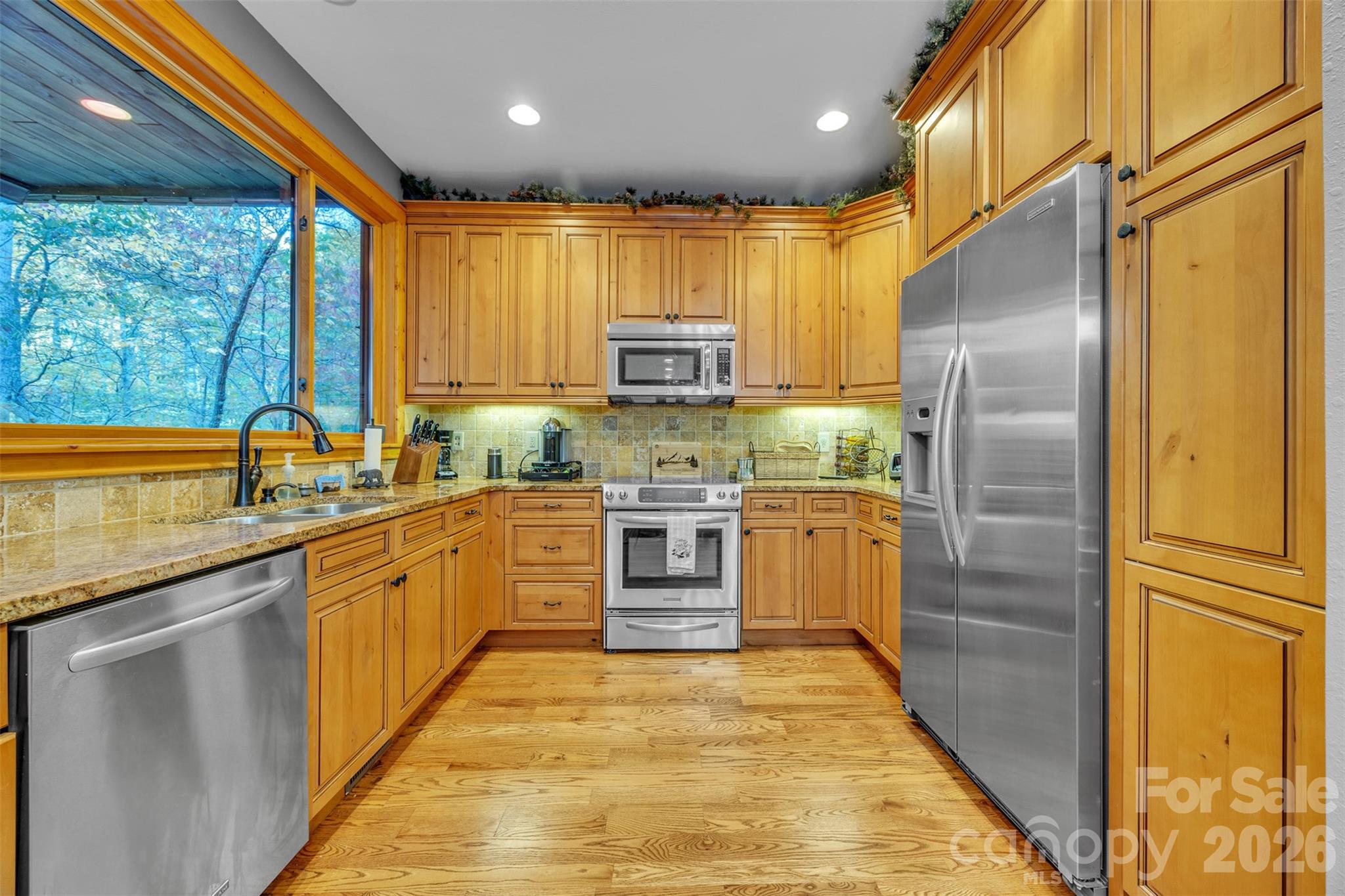 89 Springhouse Drive, Unit A4 Elk Park, NC 28622 - Photo 7 of 40 a kitchen with stainless steel appliances granite countertop a sink a stove and a refrigerator