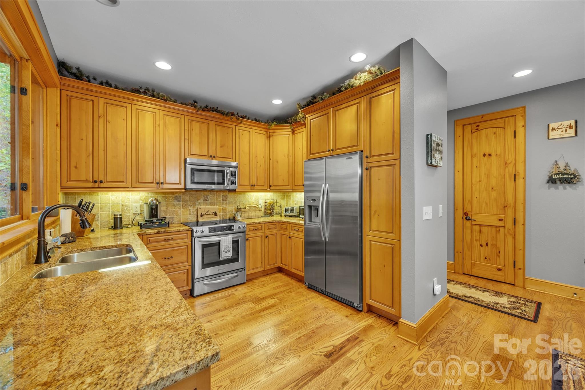 89 Springhouse Drive, Unit A4 Elk Park, NC 28622 - Photo 8 of 40 a kitchen with stainless steel appliances granite countertop a refrigerator a stove top oven and sink